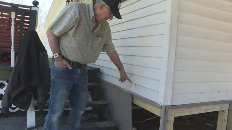 Earl Leblanc points to where the water reached on his mobile home in Maugerville. (Shane Fowler/CBC)