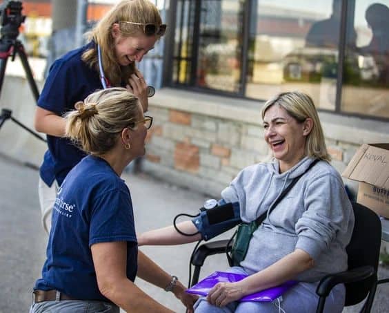 Nataliya Sobetca, who is eight months pregnant and among a group of people fleeing the war from Ukraine, receives a check-up from volunteer nurses Kim Wiebe (top) and Marcella Veenman-Mulder, after arriving at a terminal at Toronto Pearson airport on a plane from Poland, operated by Samaritan’s Purse Canada on Sunday, May 15, 2022. ERNEST DOROSZUK/TORONTO SUN