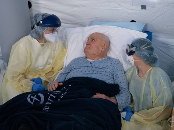 Savannah Koop, left, and fellow Calgarian Alyssa Collier tend to a 91-year-old COVID-19 patient at the Samaritan’s Purse field hospital in Cremona.